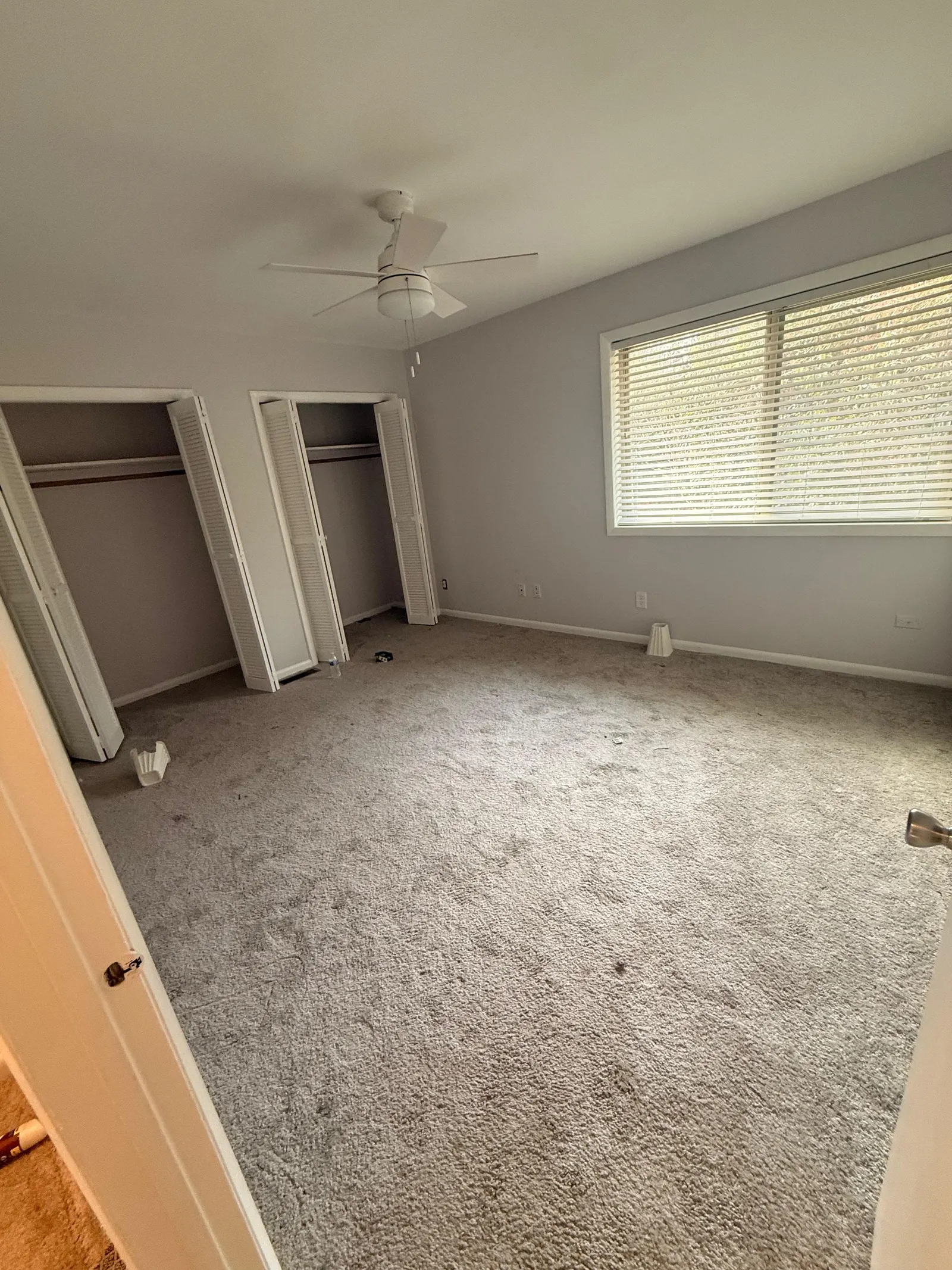 Empty bedroom with dirty carpet before a move-out cleaning